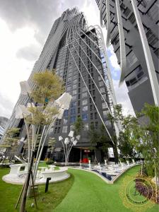 un edificio alto con un parque verde delante de él en ARTE Mont Kiara Cozy Stunning Home_Jacuzzi, en Kuala Lumpur