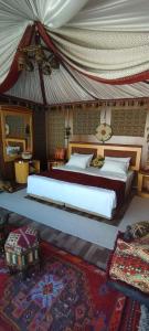 een slaapkamer met een groot bed in een tent bij Desert Sand Camp in Wadi Rum