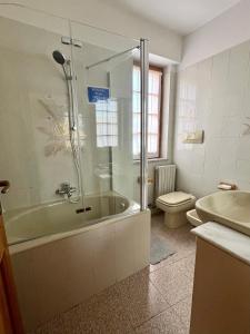 a bathroom with a shower and a tub and a toilet at Casa Elisa in Stresa