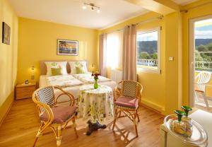 1 dormitorio con 1 cama, mesa y sillas en Panorama Hotel & Restaurant en Kröv