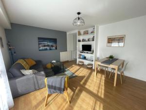 een woonkamer met een bank en een tafel bij Nant'Sud Loire in Nantes