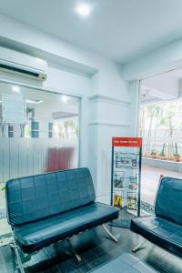 a waiting room with two blue chairs and a sign at Hotel Athome , Whitefields, Kondapur in Hyderabad