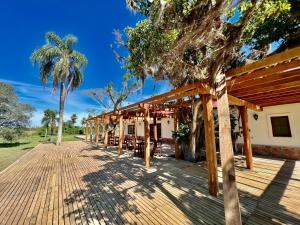 a wooden walkway leading to a building with palm trees at Estancia Iberá in Colonia Carlos Pellegrini