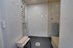 baño con ducha y taburete con toalla en Upea kolmio+sauna parhaalla paikalla! en Tampere