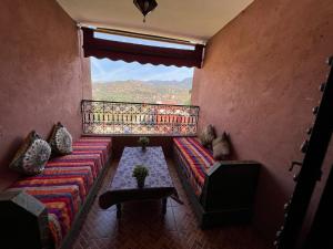 un soggiorno con un divano, un tavolo e una finestra di Maison d´hôtes Amazir a Ouzoud