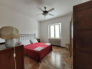 a bedroom with a red bed and a ceiling fan at La Lenzerina Casa indipendente con giardino in Scarlino