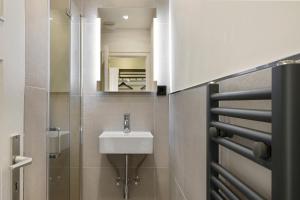 ein Bad mit einem Waschbecken und einem Spiegel in der Unterkunft The Shine - Premium Studio-HBF-Messe-Bürgerweide-CityGate-ÖVB Arena in Bremen