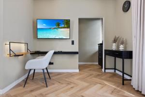 a desk and chair in a room with a television on the wall at The Shine - Premium Studio-HBF-Messe-Bürgerweide-CityGate-ÖVB Arena in Bremen