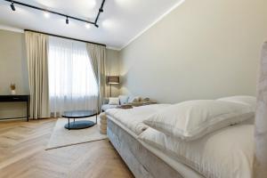 a white bedroom with a large bed and a table at The Shine - Premium Studio-HBF-Messe-Bürgerweide-CityGate-ÖVB Arena in Bremen