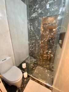 a bathroom with a toilet and a glass shower at Navega Beach Palace Hotel in Navegantes