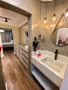 a bathroom with a sink and a mirror at Navega Beach Palace Hotel in Navegantes