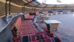 a row of benches and tables in a building at Wadi Rum Majestic Camp in Wadi Rum