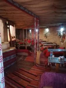 a room with many tables and chairs in a room at Wadi Rum Majestic Camp in Wadi Rum