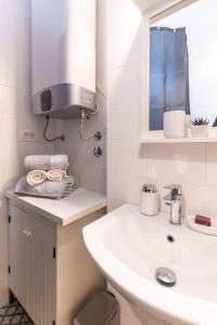 W białej łazience znajduje się umywalka i lustro. w obiekcie Seahorse9 w Splicie