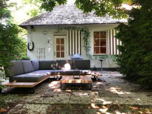 a couch and a coffee table in front of a house at Bed and Breakfast De Haen - Privé-appartementen van 43 of 60 m2 met tweepersoons bubbelbad - Finse sauna - in westvleugel van luxe villa in Oss