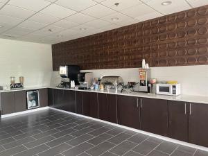 a kitchen with brown cabinets and a counter top at Wingate by Wyndham Savannah Gateway in Savannah