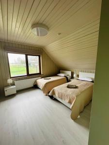 a bedroom with two beds and a large window at Green Town in Vievis