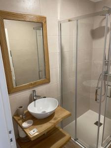 La salle de bains est pourvue d'un lavabo et d'une douche. dans l'établissement Alojamento Sudoeste, à Zambujeira do Mar