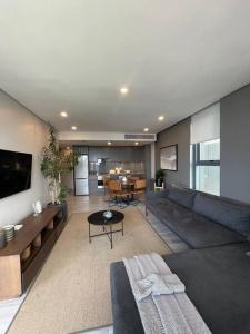 a living room with a couch and a table at Umhlanga Arch Sea View Apartment in Durban