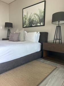 a bedroom with a bed with two lamps on it at Umhlanga Arch Sea View Apartment in Durban
