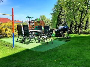 a table and chairs in a yard with a playground at Apartament Family First in Karpacz
