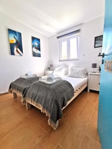 1 dormitorio con 2 camas y ventana en International Surf School & Camp, en Sagres