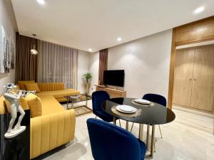 sala de estar con sofá amarillo y mesa en ZEN Suites Hotel Massira, en Casablanca