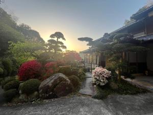 un jardín con flores y rocas y un edificio en みやうら御殿 en Imabari