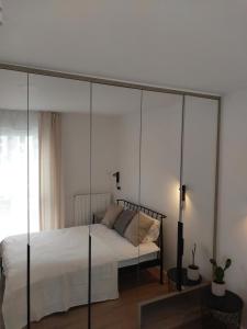 羅茲的住宿－Fuzja Ana - Garaż - Klimatyzacja - Dostęp na Kod - FV，卧室配有带玻璃墙的天蓬床