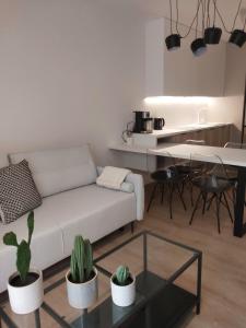 salon z białą kanapą i stołem w obiekcie Fuzja Ana - Garaż - Klimatyzacja - Dostęp na Kod - FV w Łodzi