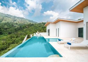 a swimming pool with a view of a house at Vimaan Vilai - Secluded Pool Villa in Amphoe Koksamui