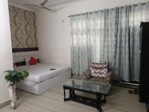 a living room with a couch and a chair and a table at Viraj Guest House in Noida