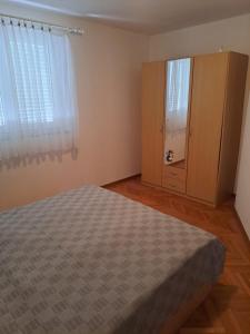 una camera da letto con un letto e un armadio in legno di Apartment Zarok 2 a Baška