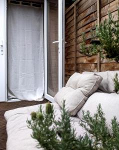 a bed sitting on a porch next to a window at Garden Studio Annex w/free parking in Hemel Hempstead