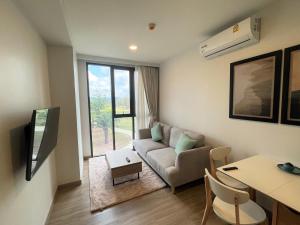een woonkamer met een bank en een tafel bij Brand new Condo in Laguna near golf course in Bang Tao Beach