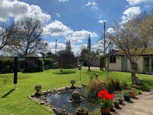 a garden with a pond with flowers in a yard at The Nest at Walnut Cottage in Burrowbridge