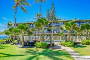un bâtiment avec des palmiers en face de celui-ci dans l'établissement Kauai Kailani Resort #109, à Kapaa