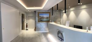 un baño con una pintura en la pared y un pasillo en Hotel Centrale, en Riva del Garda
