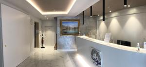 a bathroom with a painting on the wall and a hallway at Hotel Centrale in Riva del Garda