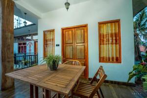 a wooden table with a potted plant on top of a room at Hotel Athina & Restaurant in Chilaw