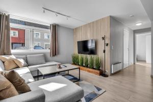 a living room with a couch and a tv at Arctic Homes - The Aurora Retreat in Tromsø