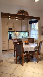eine Küche mit einem Tisch und einigen Stühlen sowie einem Tisch und einer Küche in der Unterkunft *Weigelt - Ferienwohnung Issy in Greetsiel