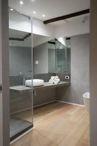 a bathroom with a glass shower with a sink at Residence Cortile Mercè in Trapani