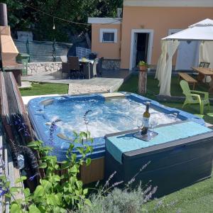 a hot tub with a bottle of wine in a yard at Kuća Melita -jacuzzi in Kastav
