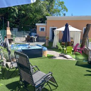 a yard with a pool and chairs and an umbrella at Kuća Melita -jacuzzi in Kastav