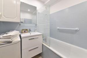 biała łazienka z umywalką i lustrem w obiekcie Studio St Jean à Roquebrune, proche Menton et Monaco w mieście Roquebrune-Cap-Martin