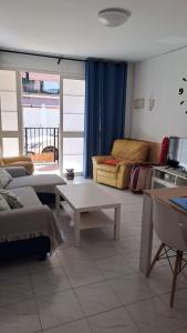 a living room with a couch and a table at CASA SANTO a 2 minutos de la playa a pié y parking gratuito in Cala del Moral