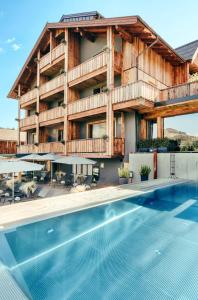 hotel z basenem przed budynkiem w obiekcie ALMMONTE SENSUM SUITES Boutique Hotel w mieście Wagrain