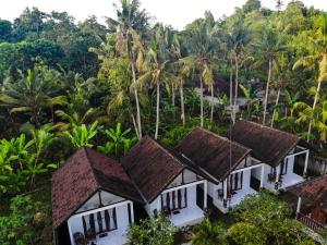 an aerial view of a resort with coconut trees at Kubu Indah Guest House in Nusa Penida