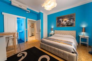 1 dormitorio azul con 1 cama y una pintura en la pared en Pisa Happy House 5, en Pisa